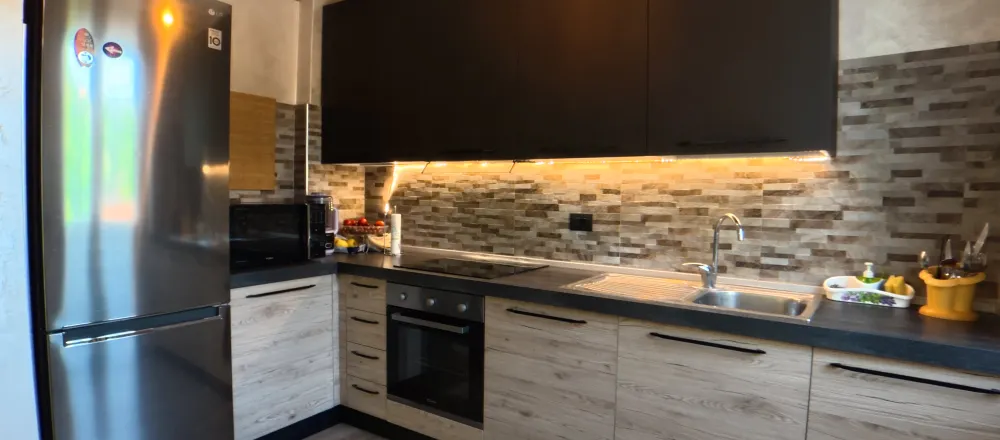 Cucina a vista con elettrodomestici in acciaio e piano cottura a induzione