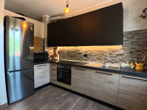 Cucina a vista con elettrodomestici in acciaio e piano cottura a induzione
