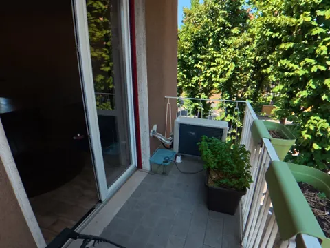 Balcone del soggiorno con vista sul verde e unità esterna del climatizzatore